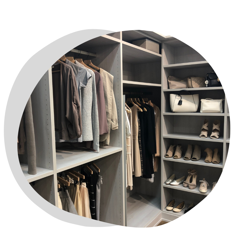 An organized walk-in closet with neatly arranged clothes and shoes.