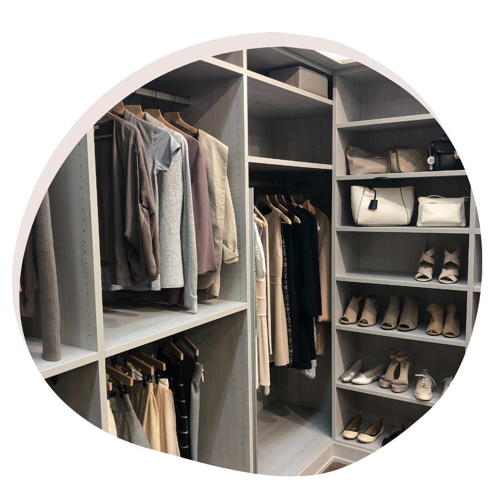 A well-organized closet with neatly arranged clothes and shoes.