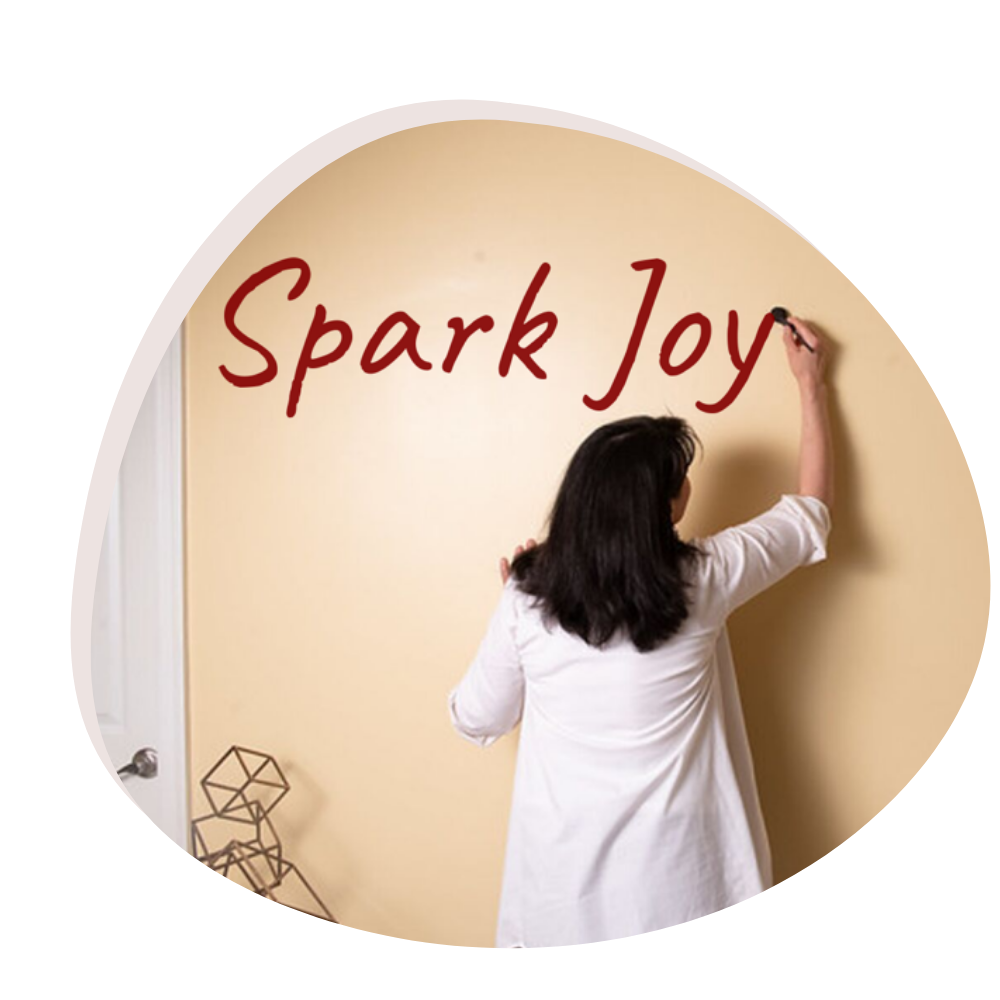A person painting the phrase "spark joy" on a wall.